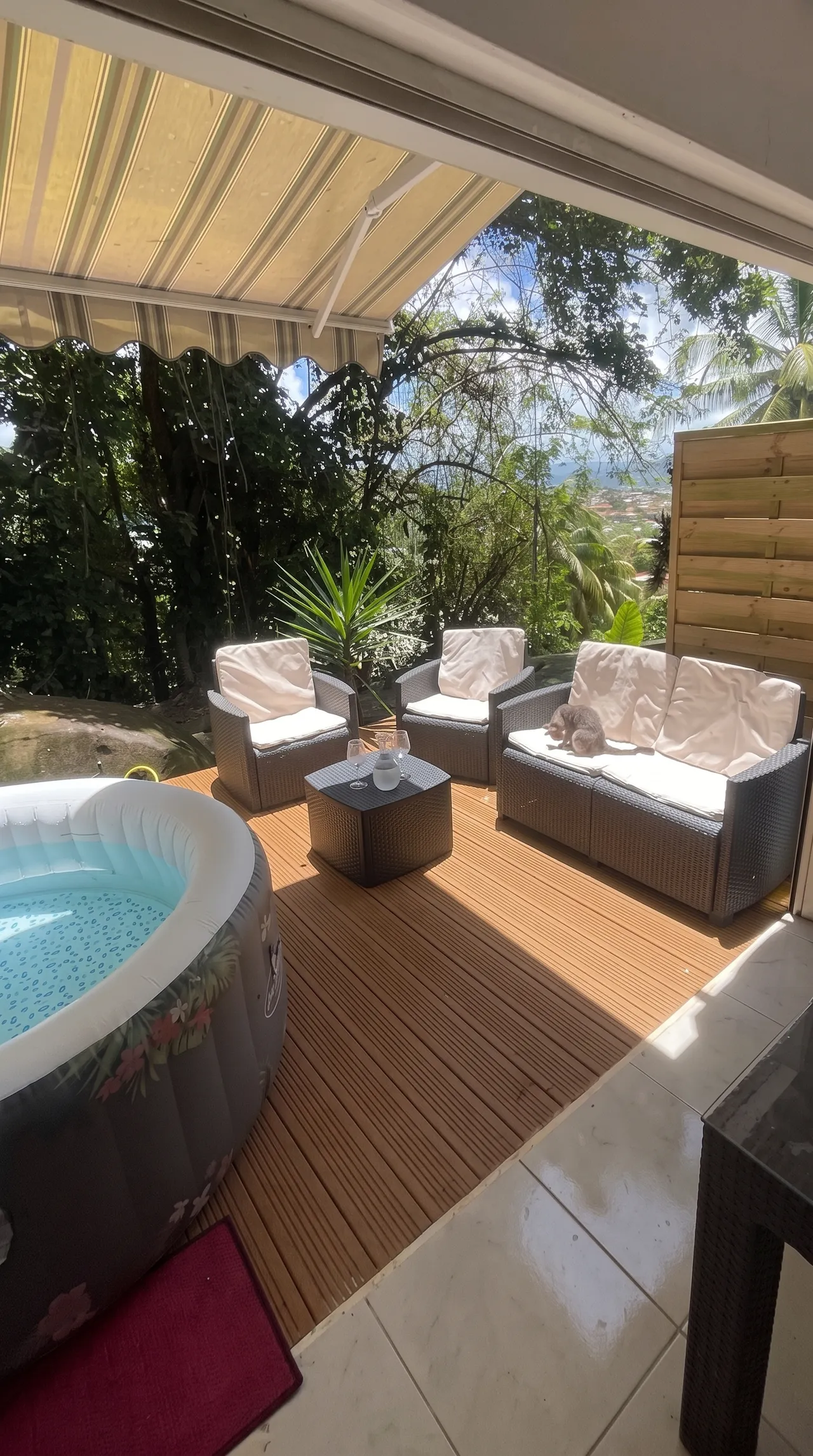 Vue sur l'extérieur de la terrasse, jacuzzi 2 personnes, petit salon de jardin et vue sur la nature