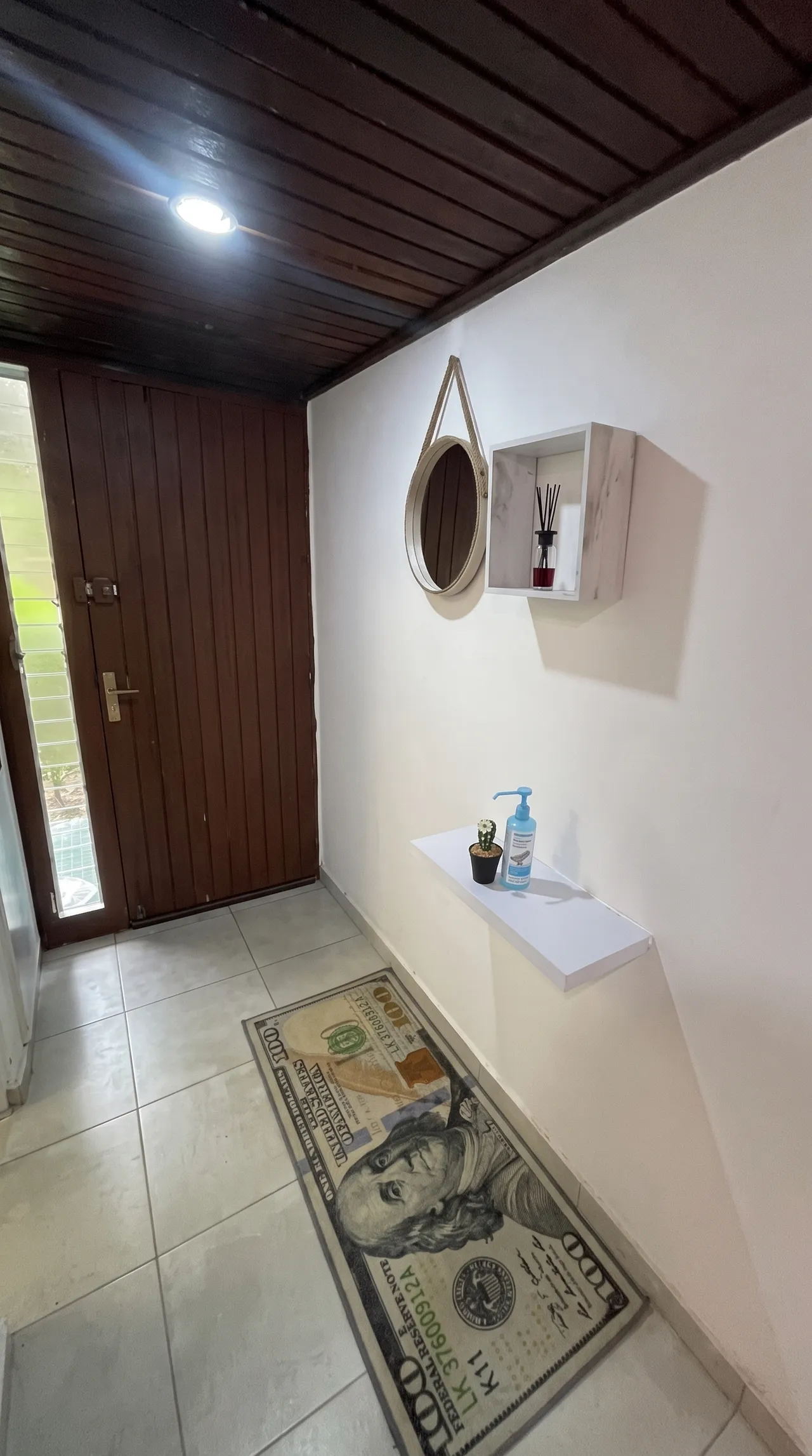 Entrée de l'appartement avec un tapis, une petite étagère